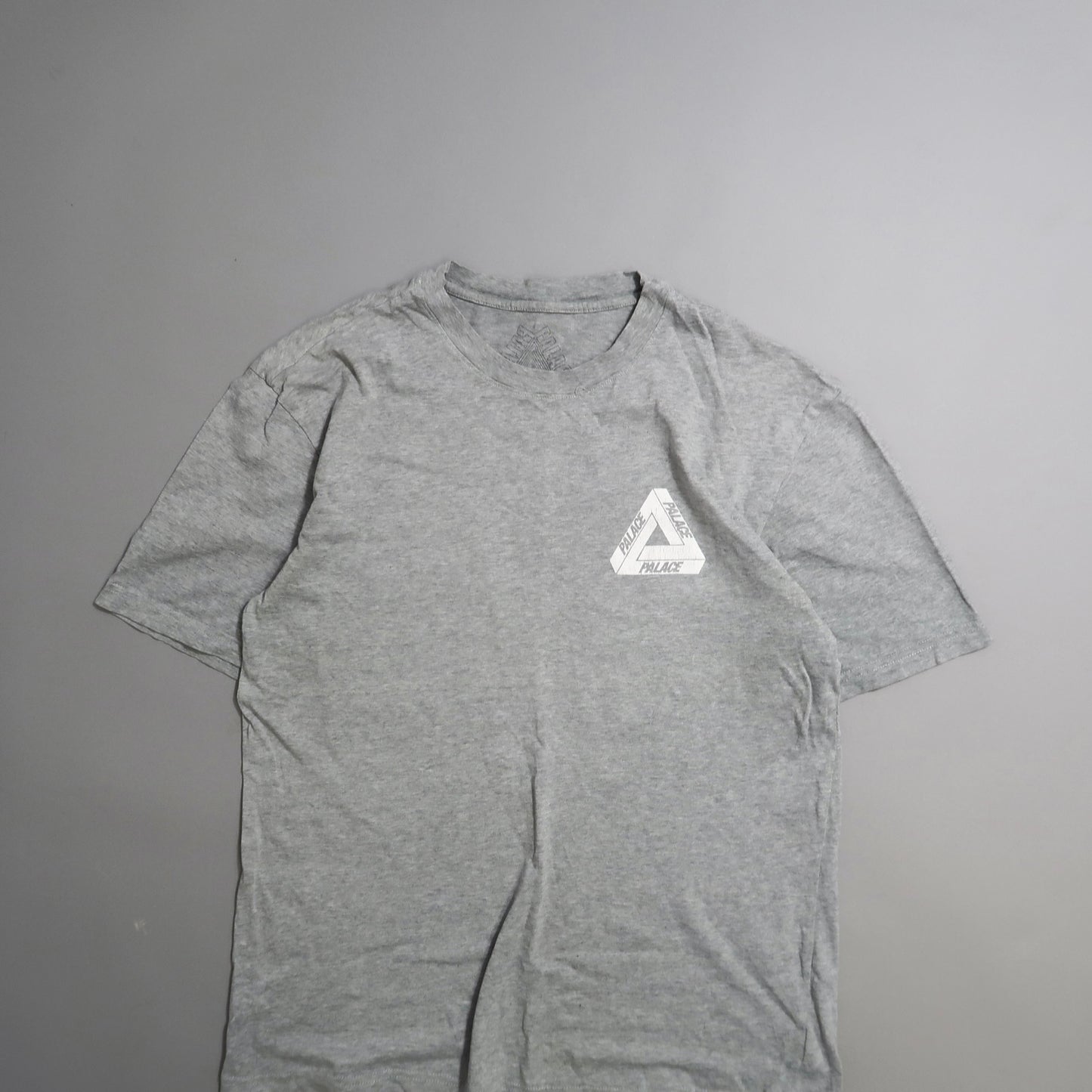 Gray T-shirt with triangular logo on the left chest.