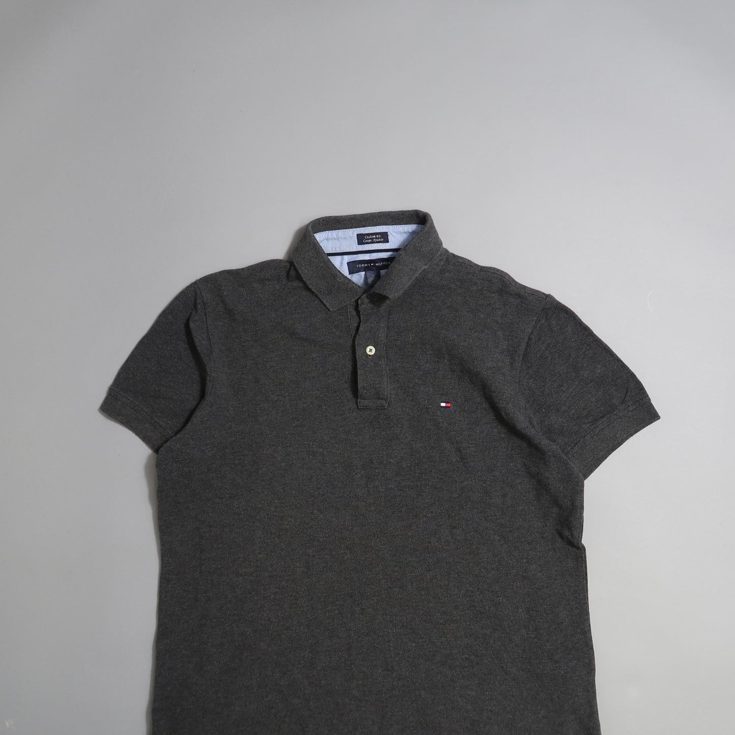Dark gray polo shirt displayed on a light gray background.