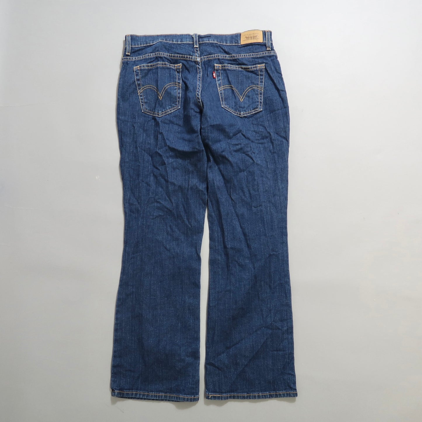 Rear view of blue denim jeans on a flat surface.
