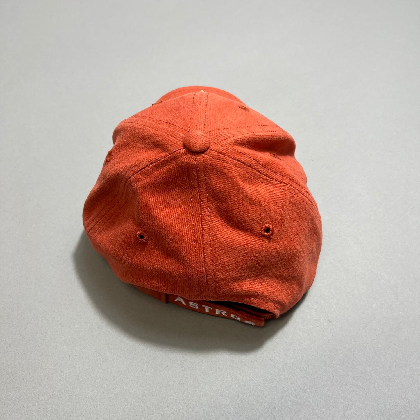 Orange baseball cap with visible stitching and a label.