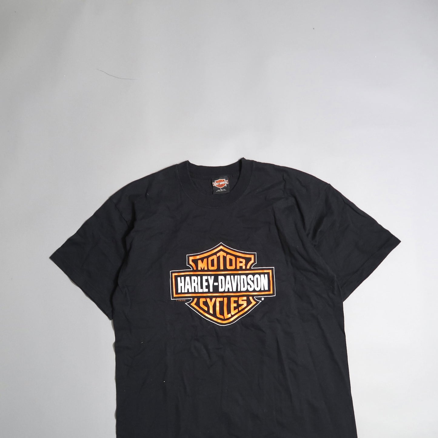 Black Harley-Davidson t-shirt with orange logo centered.