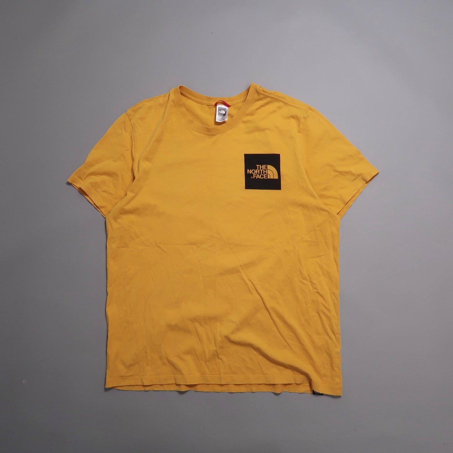 Yellow T-shirt with black nullThe North Facenull logo on front.