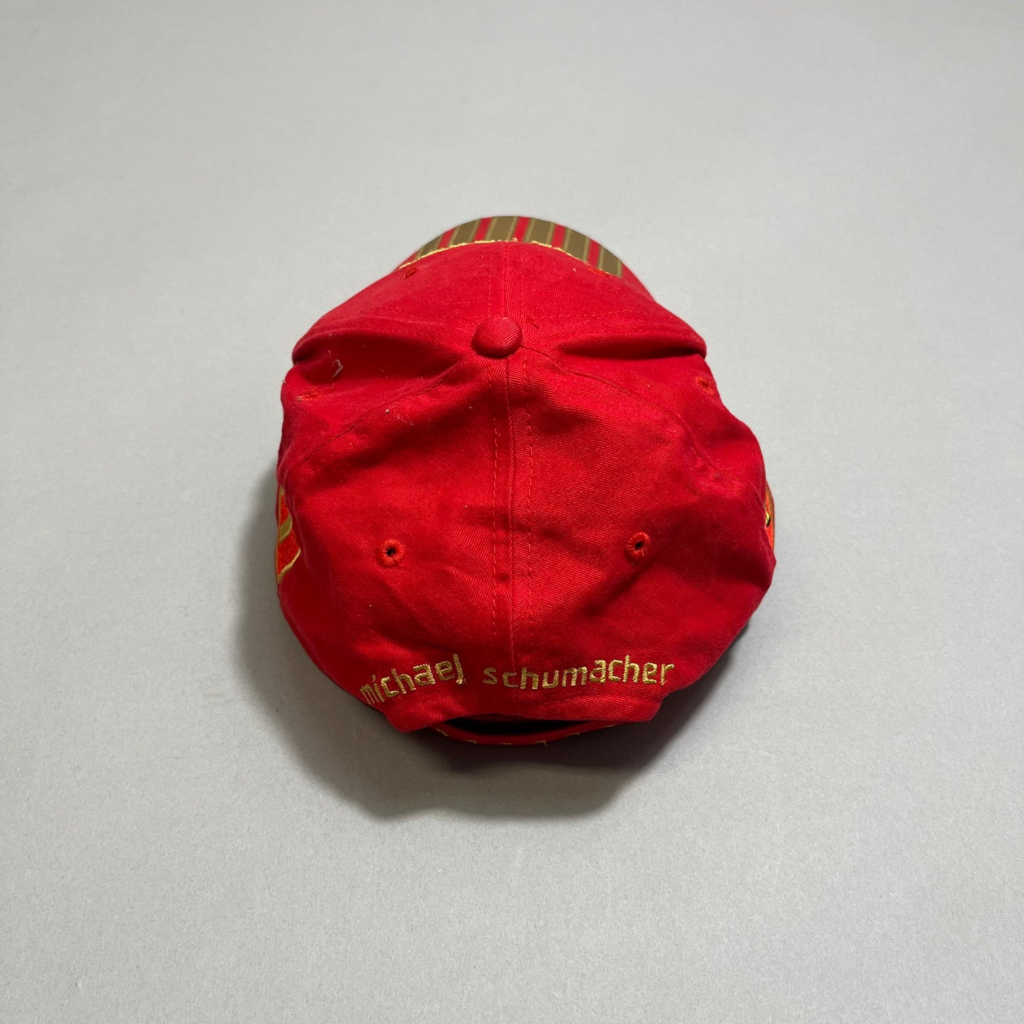 Red cap with embroidery, viewed from the back.