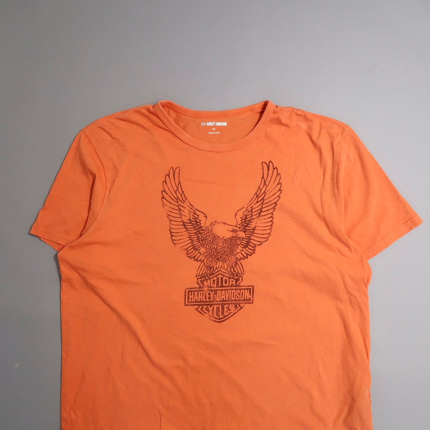 Orange T-shirt with eagle graphic and Harley-Davidson logo.