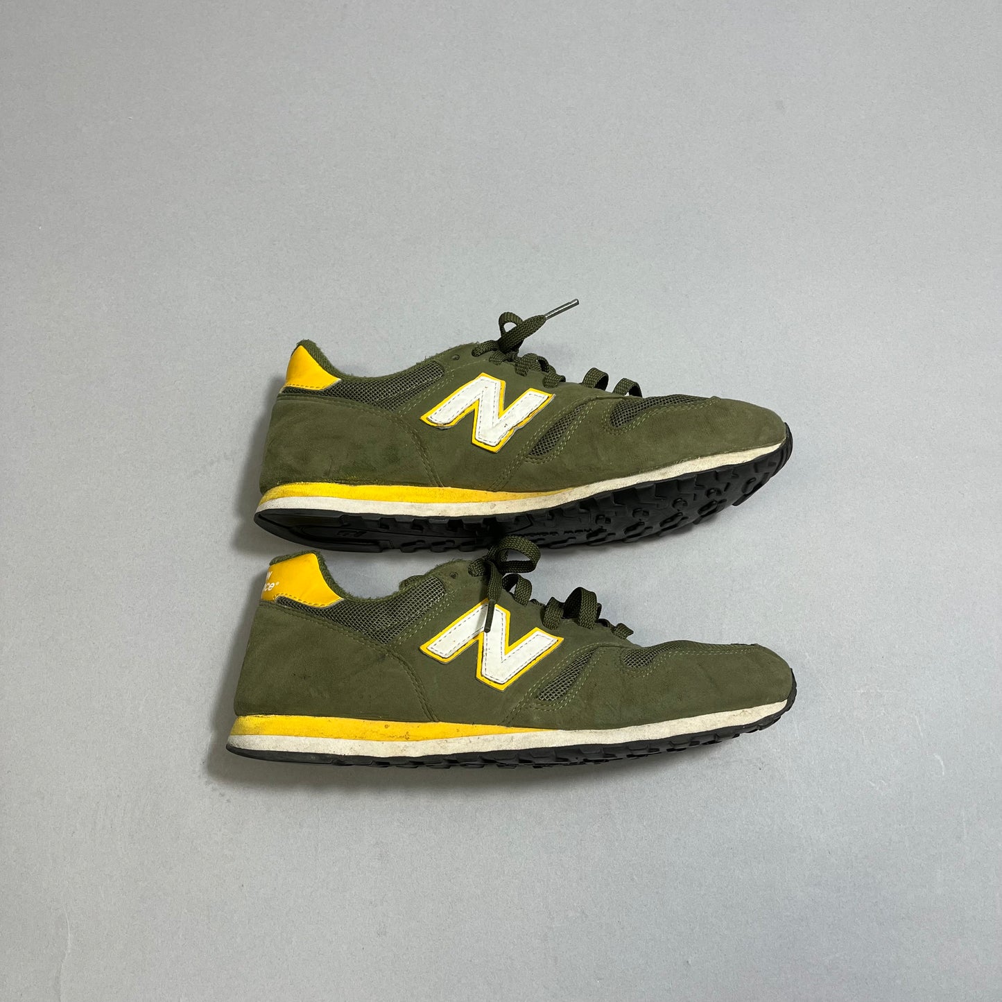 Pair of green and yellow sneakers with a white nullNnull logo on the side.
