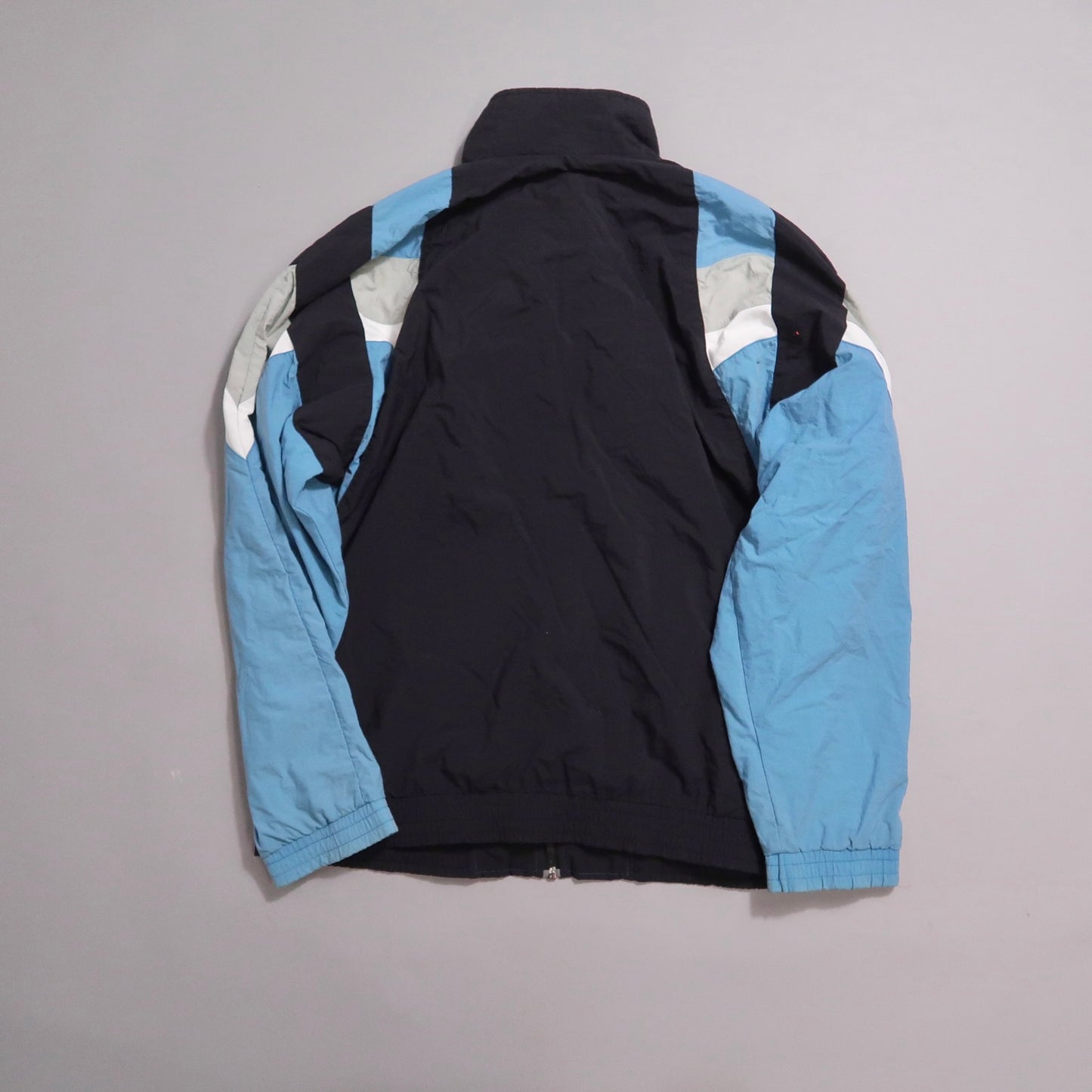 Navy and blue jacket with white and grey accents, displayed on a flat surface.