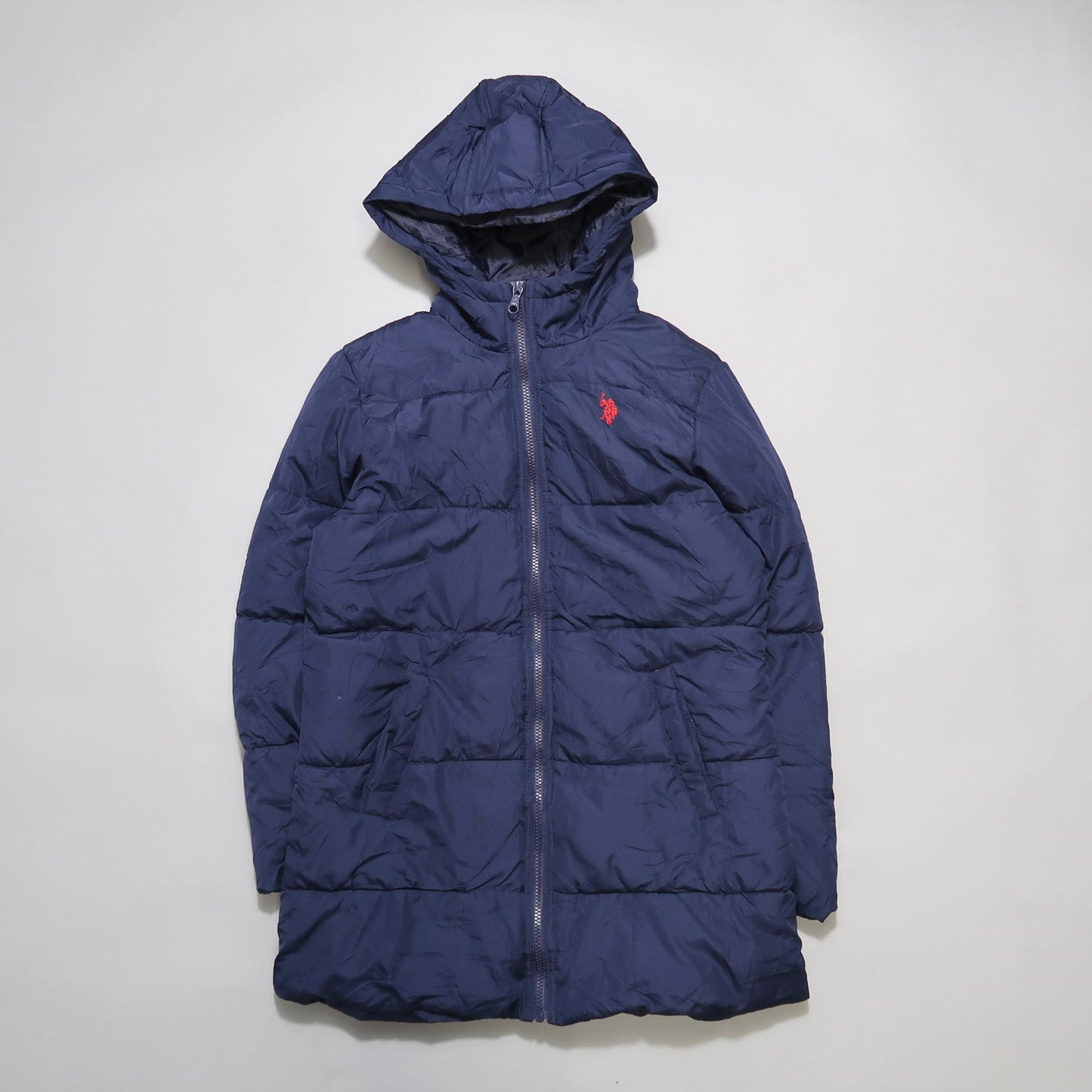 Navy blue puffer jacket with hood and red logo on the chest.
