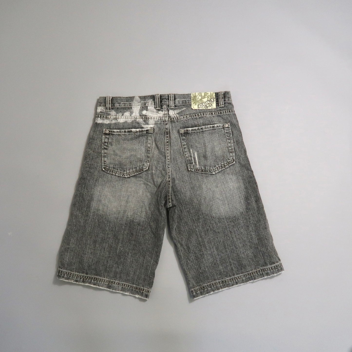Gray denim shorts on a flat gray background.