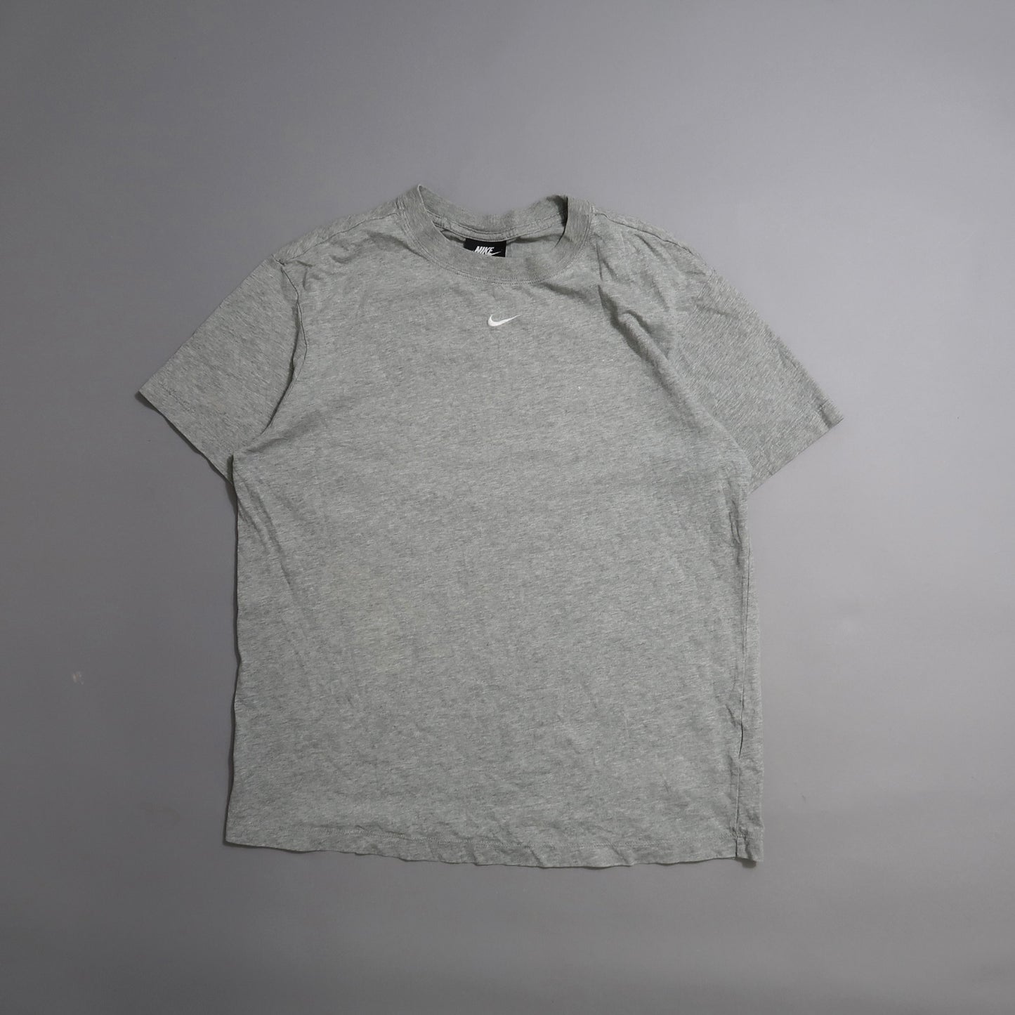 Gray Nike T-shirt on a neutral background.