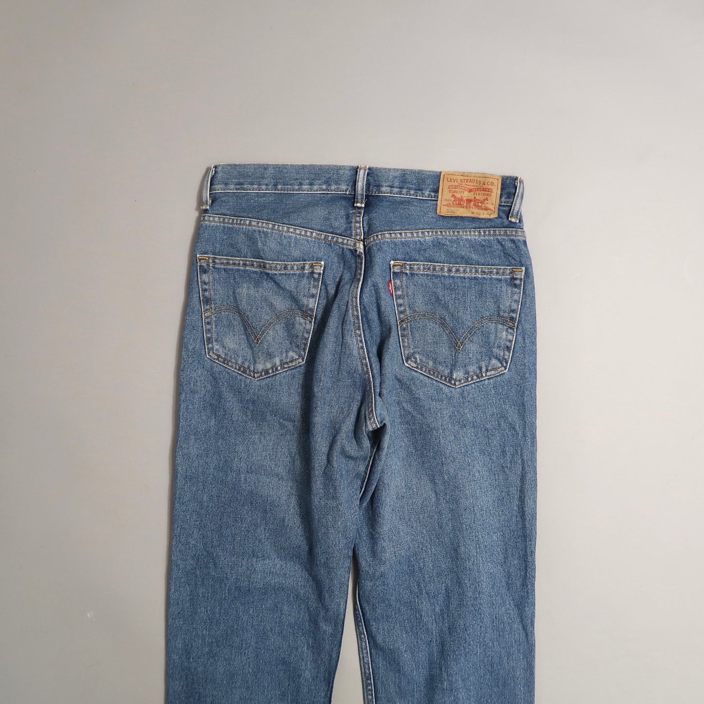 Back view of classic blue jeans with leather patch on waistband.