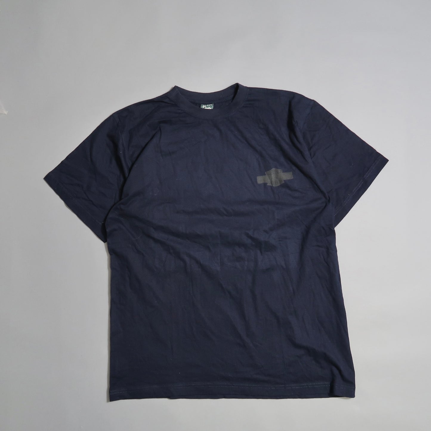 Dark blue T-shirt with subtle chest logo on light gray background.