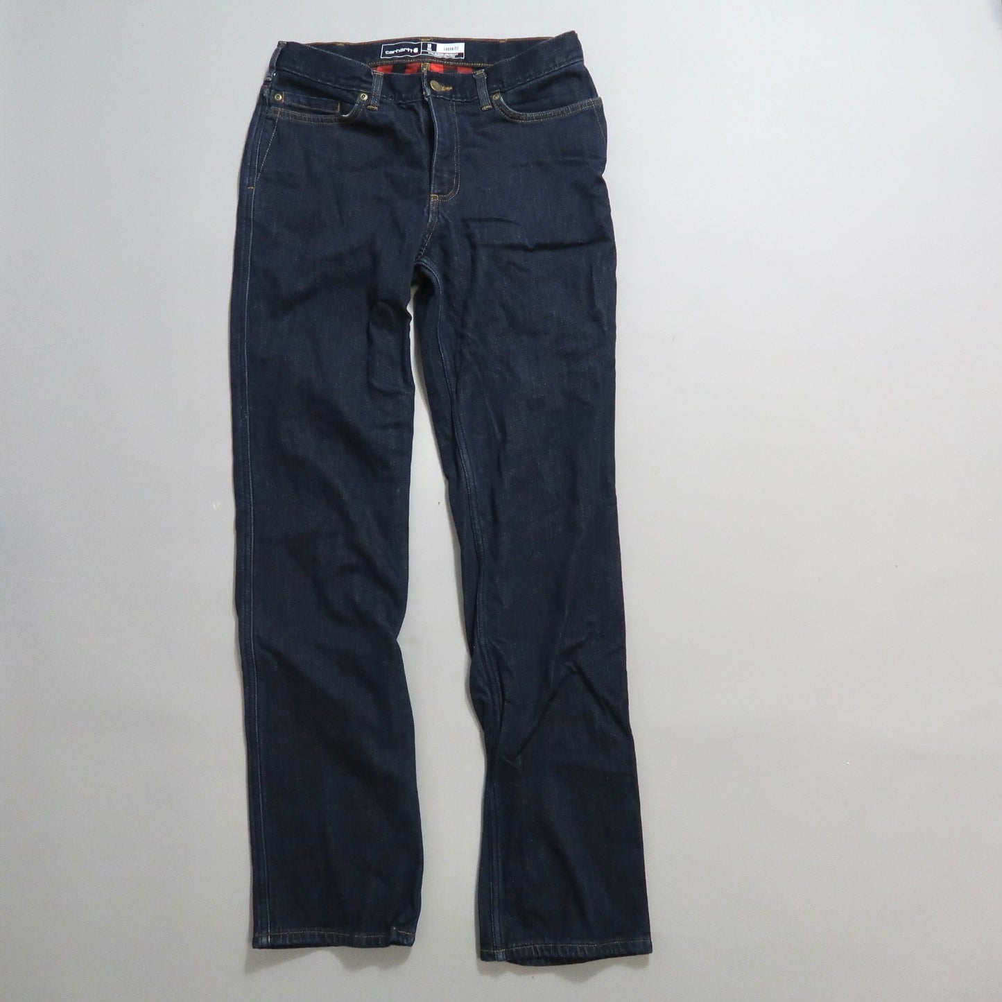 Dark blue jeans laid flat on a white surface.
