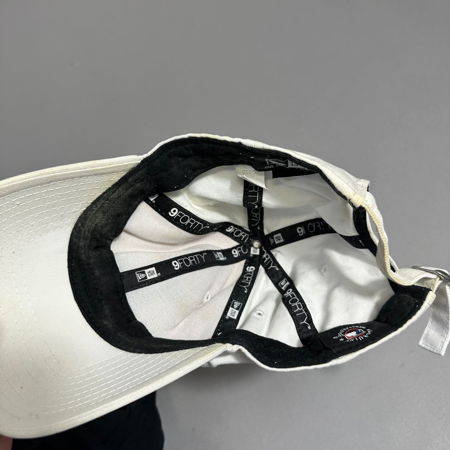 Inside view of a white 9FORTY cap showing labels and stitching.