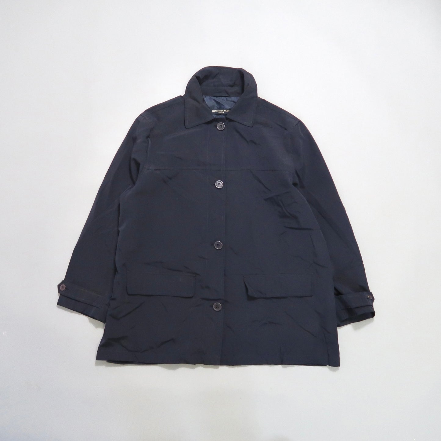 Dark blue buttoned coat on a white background.