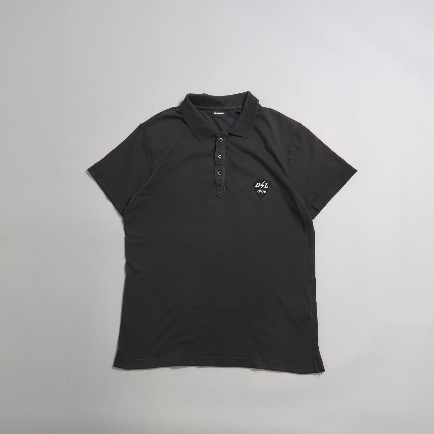 Dark gray polo shirt with small white logo on the chest.