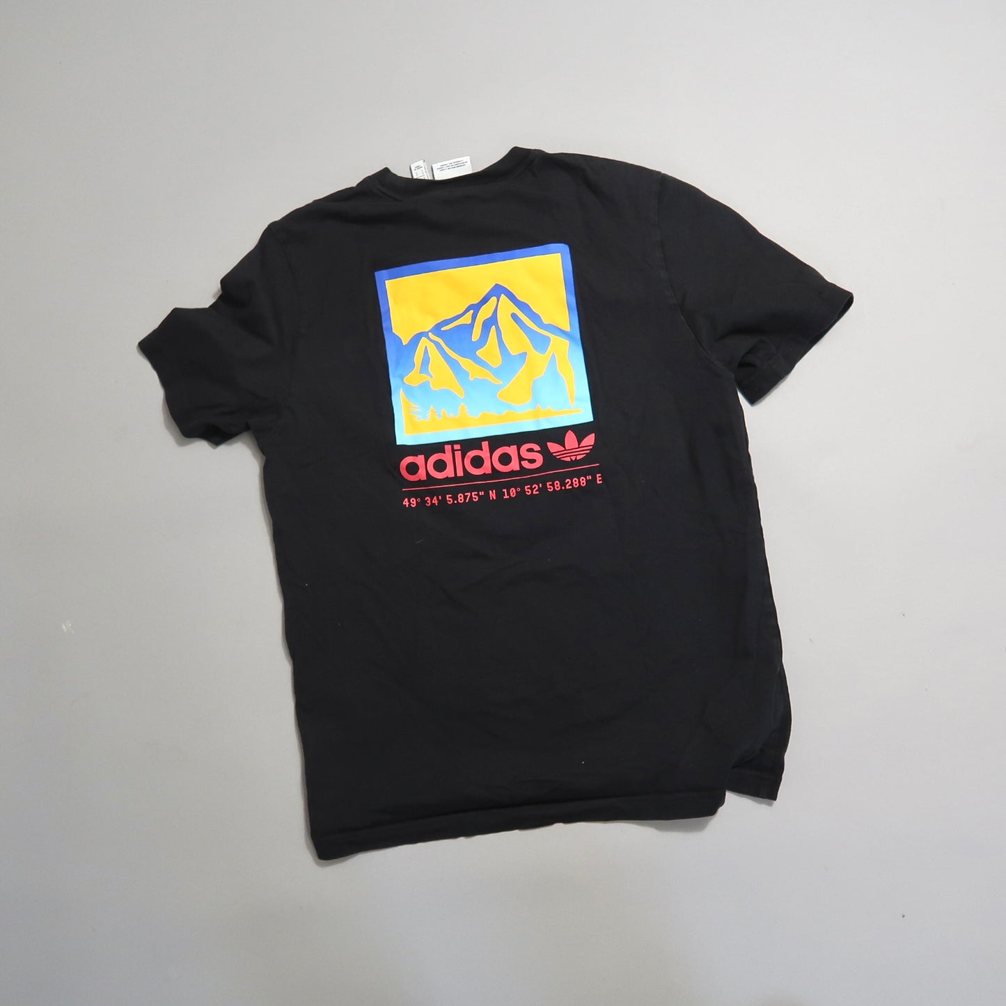 Black Adidas t-shirt with a colorful mountain graphic and coordinates.