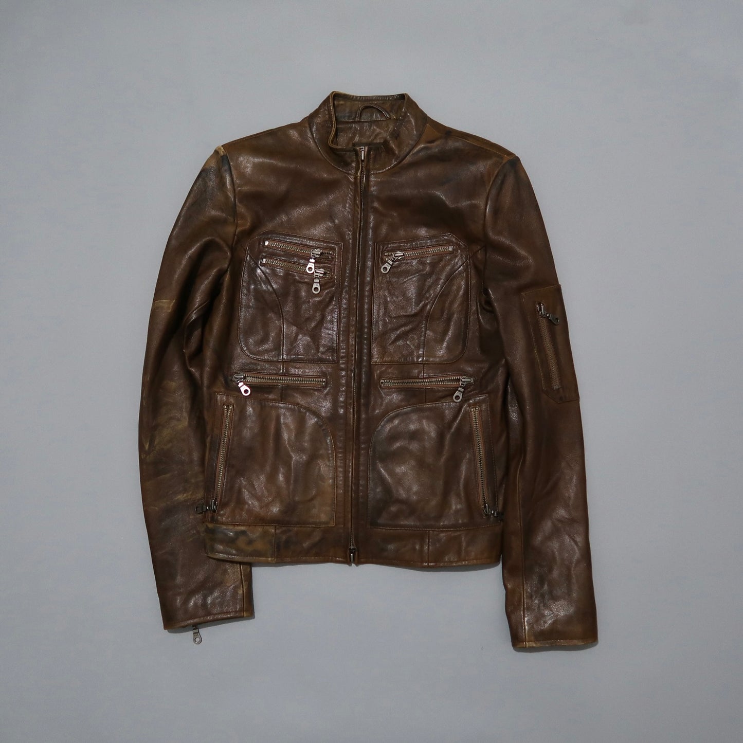 Brown leather jacket with multiple zippered pockets.