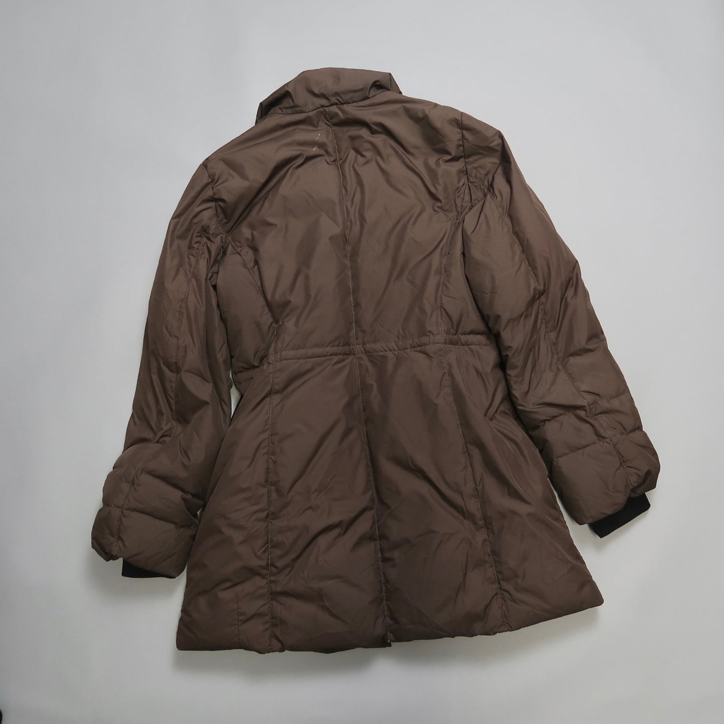 Brown puffer coat lying flat on a gray surface.