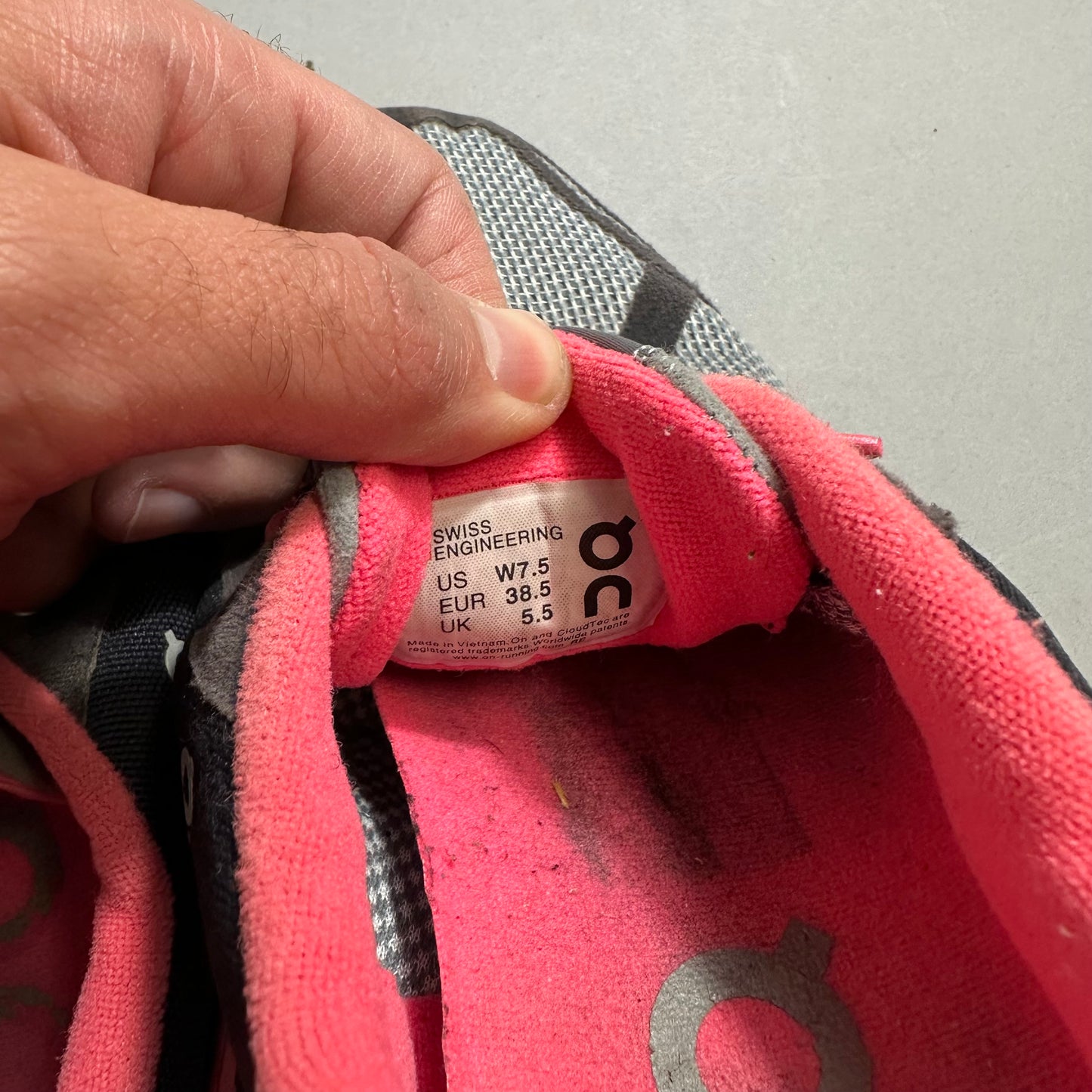 Hand holding a shoe with Swiss size tag details inside.