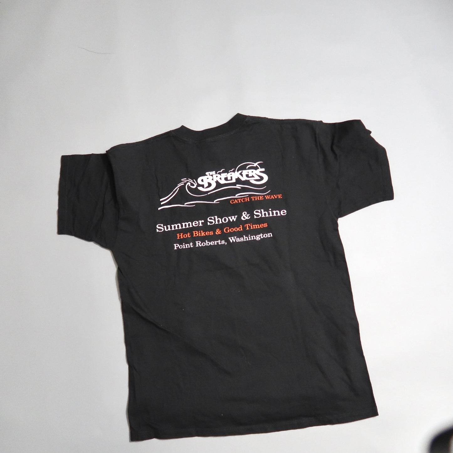 Black T-shirt with white and red event text on the back.