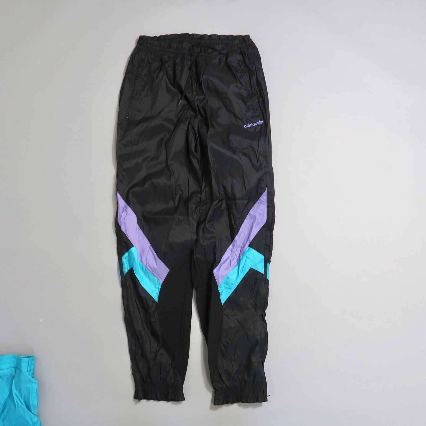 Black track pants with purple and teal chevron accents.