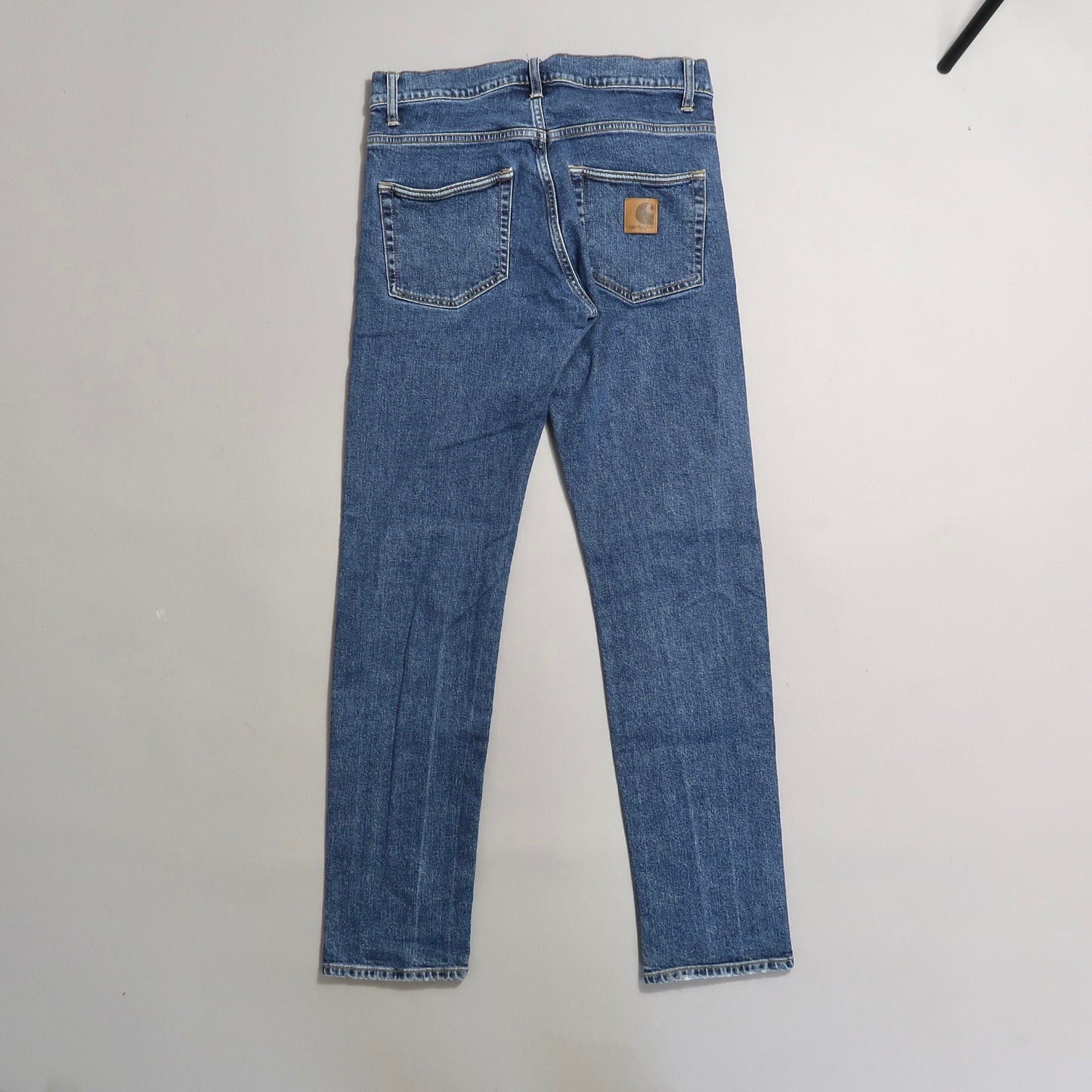 Blue jeans with a brown logo patch on the back pocket.