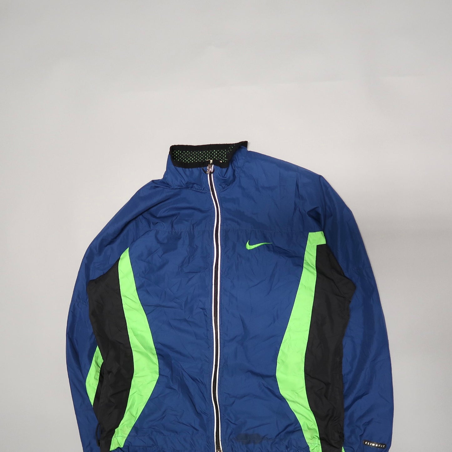 Blue and green zippered sports jacket against a light background.