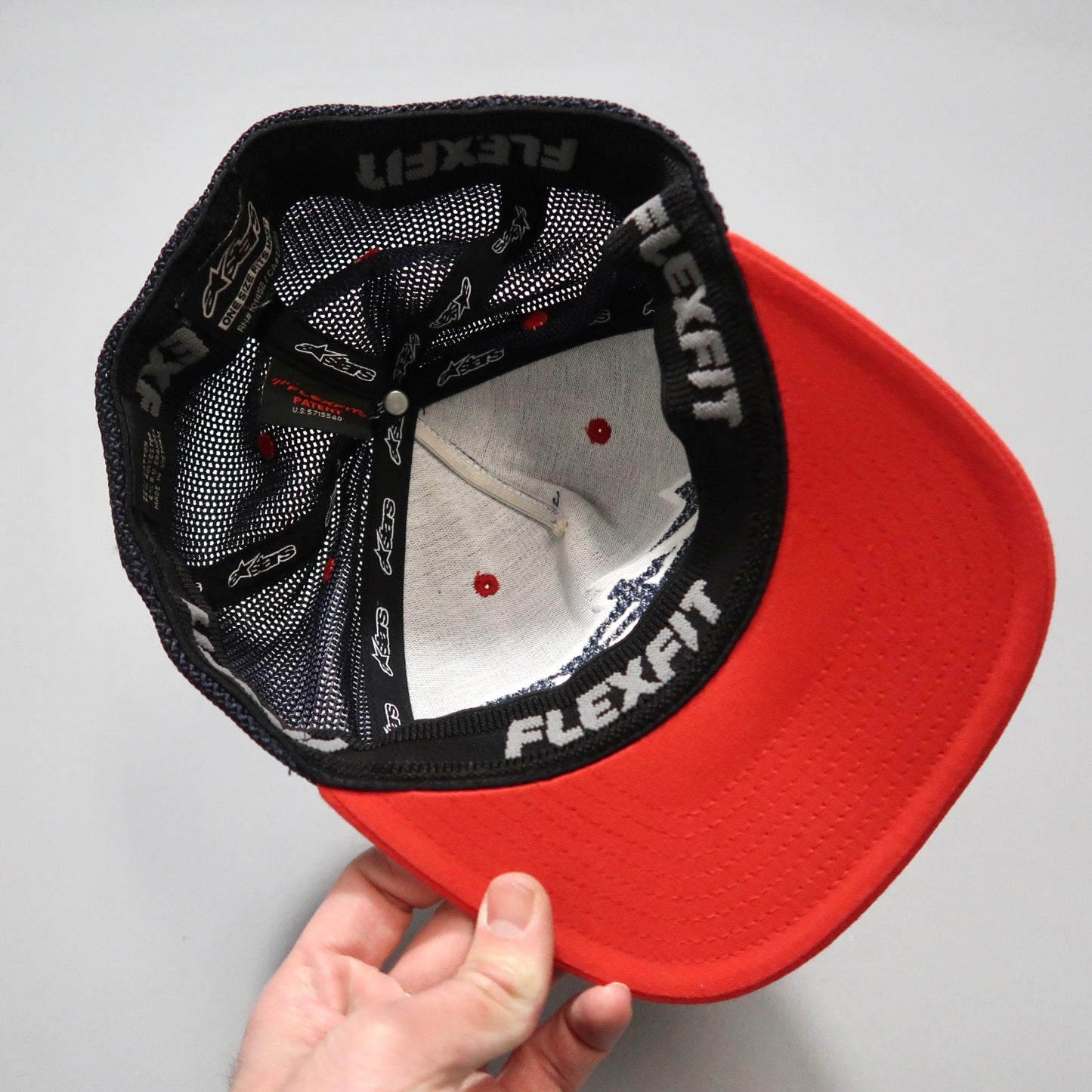 Inside view of a red Flexfit baseball cap held by hand.
