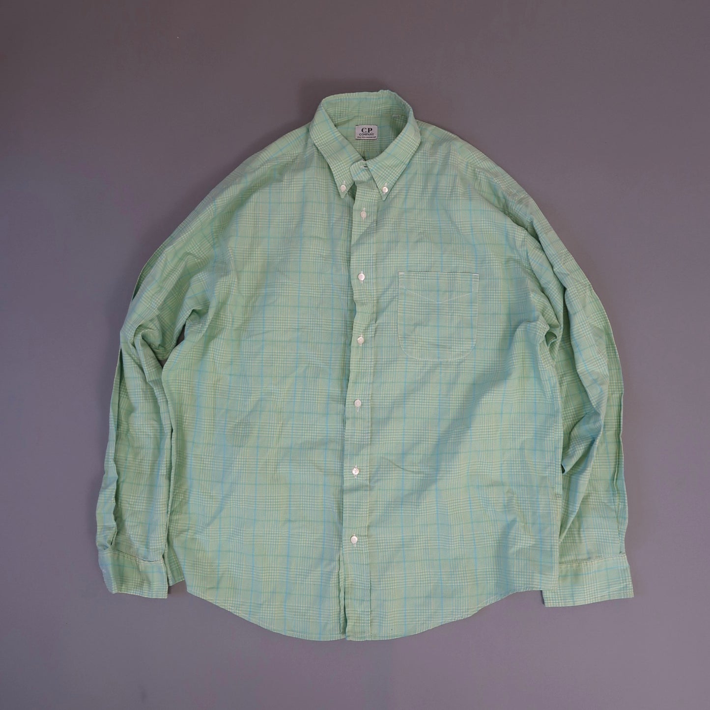 Light green plaid button-up shirt on a gray background.