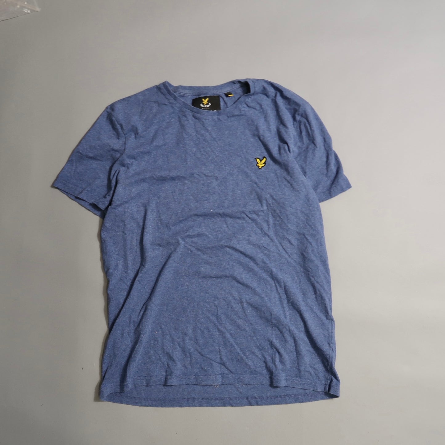 Blue T-shirt with yellow bird logo on gray background.