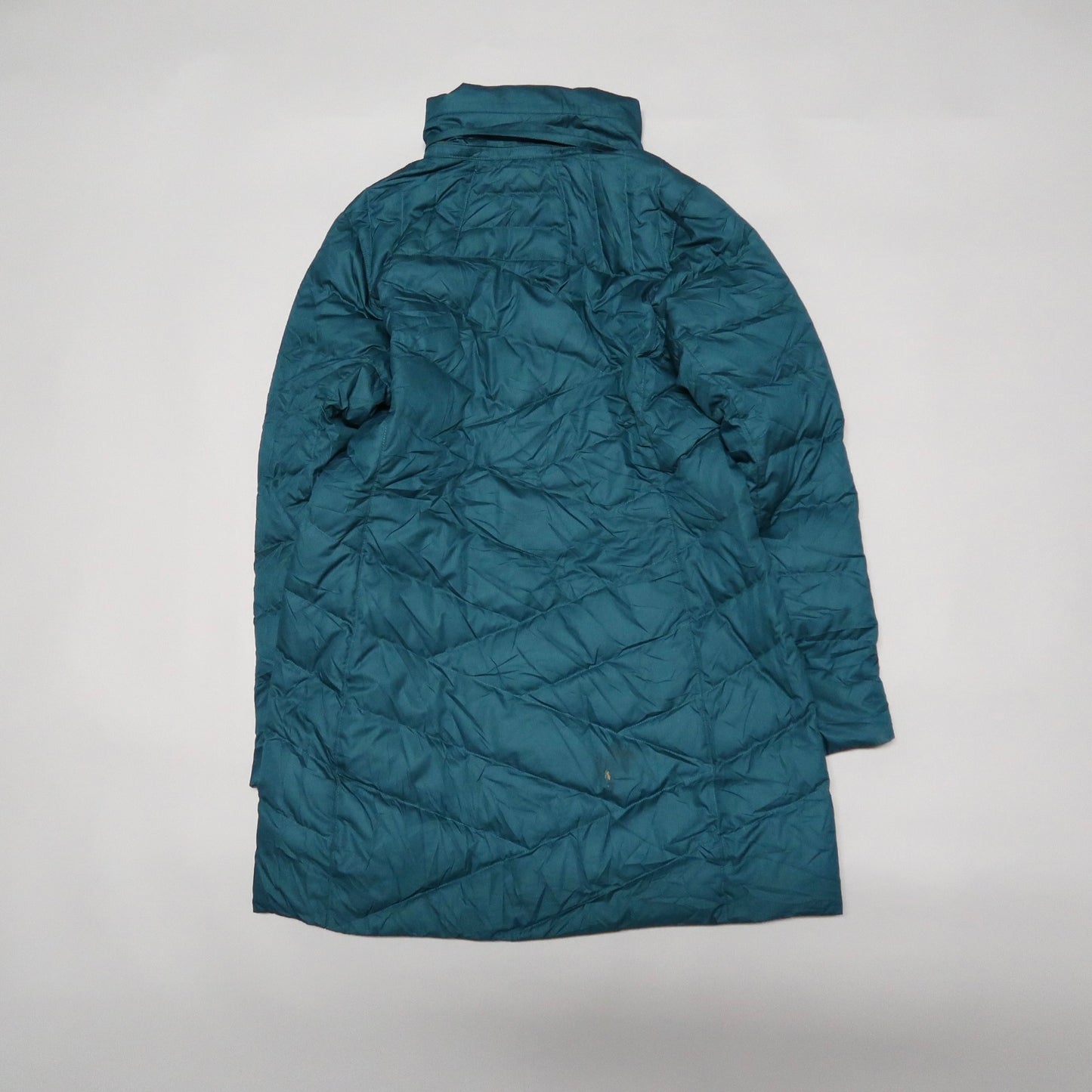 Teal quilted coat with high collar on plain background.