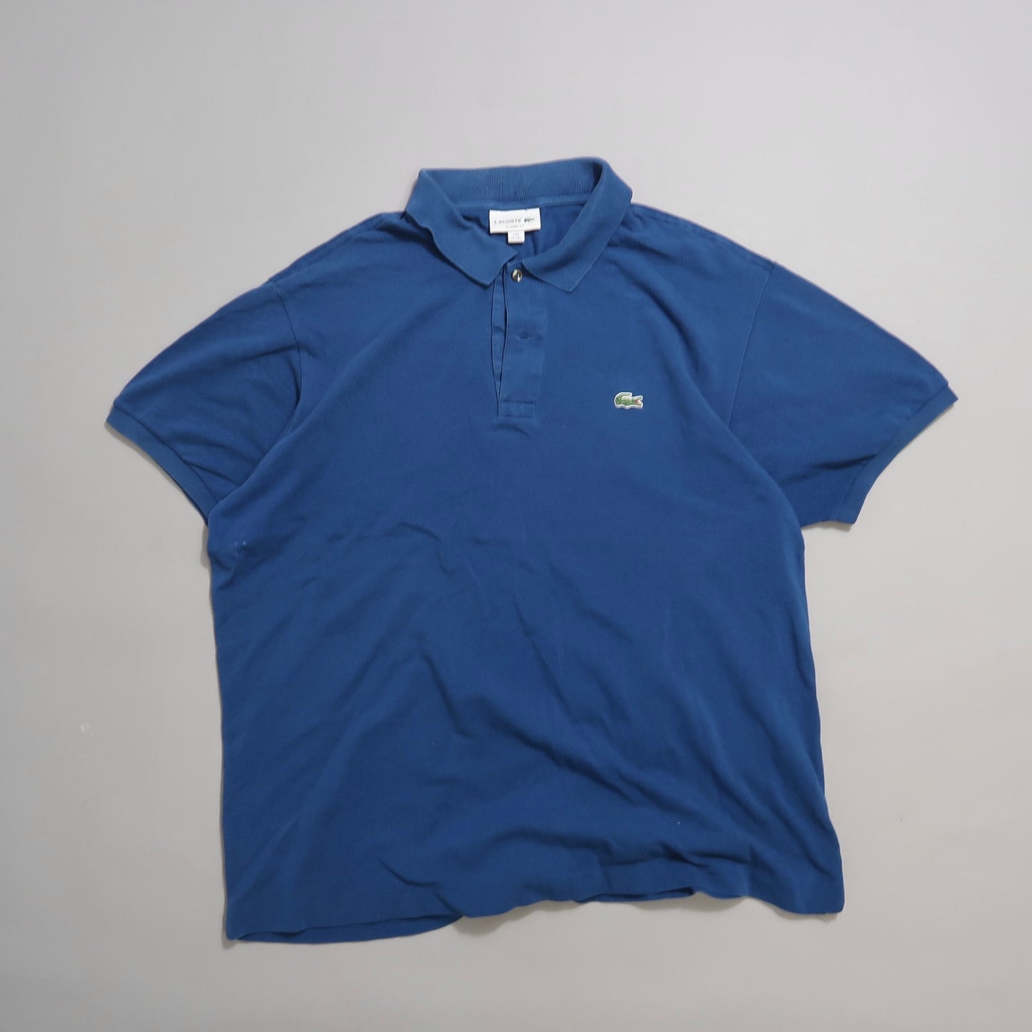 Blue polo shirt on a plain background.