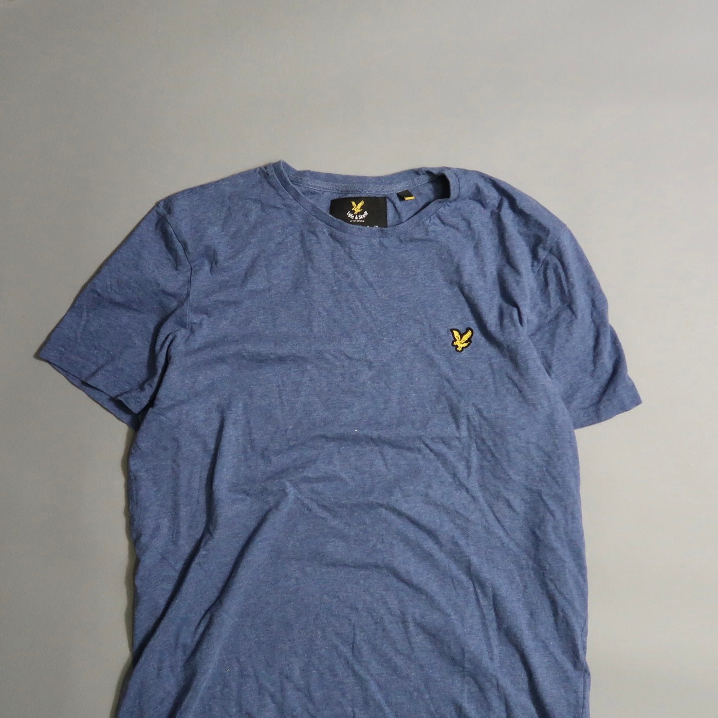 Blue T-shirt with a small yellow bird logo on the chest.