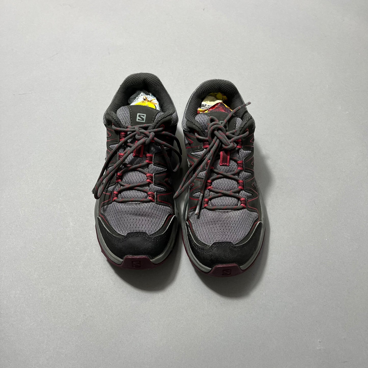 Gray and black sneakers with red accents on a gray background.