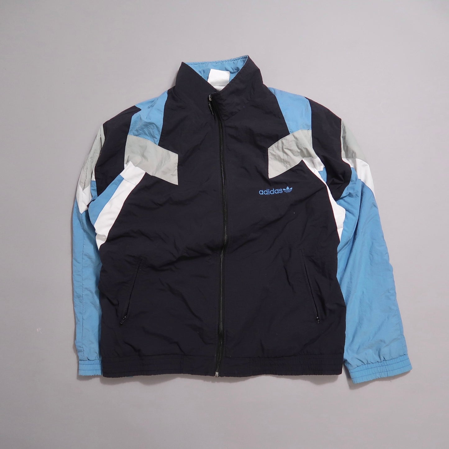 Blue and black Adidas track jacket with geometric design.