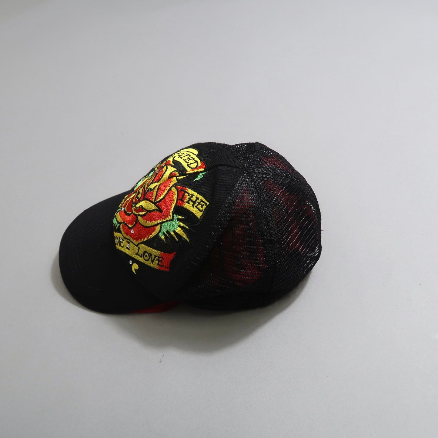 Black cap with colorful embroidered patch design.