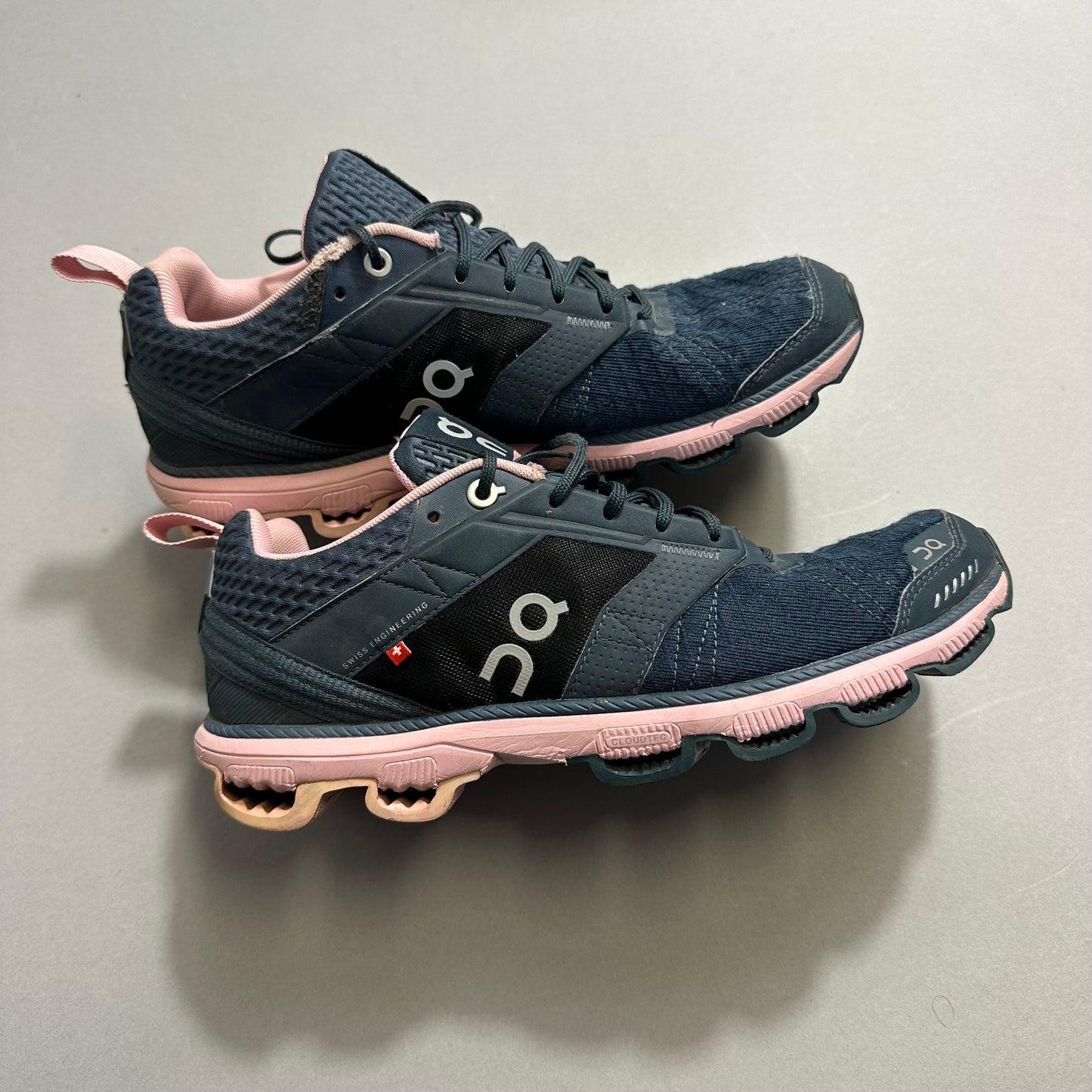 Navy and pink running shoes with unique sole design.