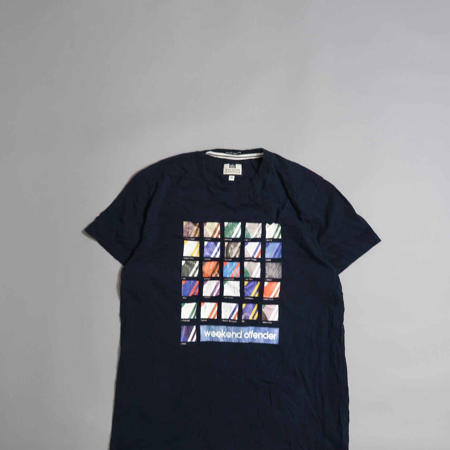 Navy t-shirt with colorful square pattern and nullweekend offendernull text.