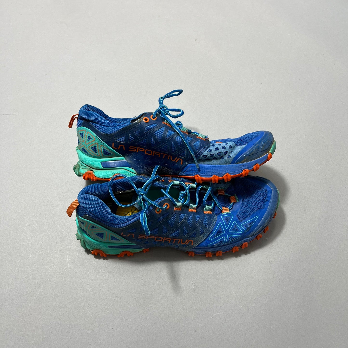 Pair of blue La Sportiva trail running shoes with orange soles.