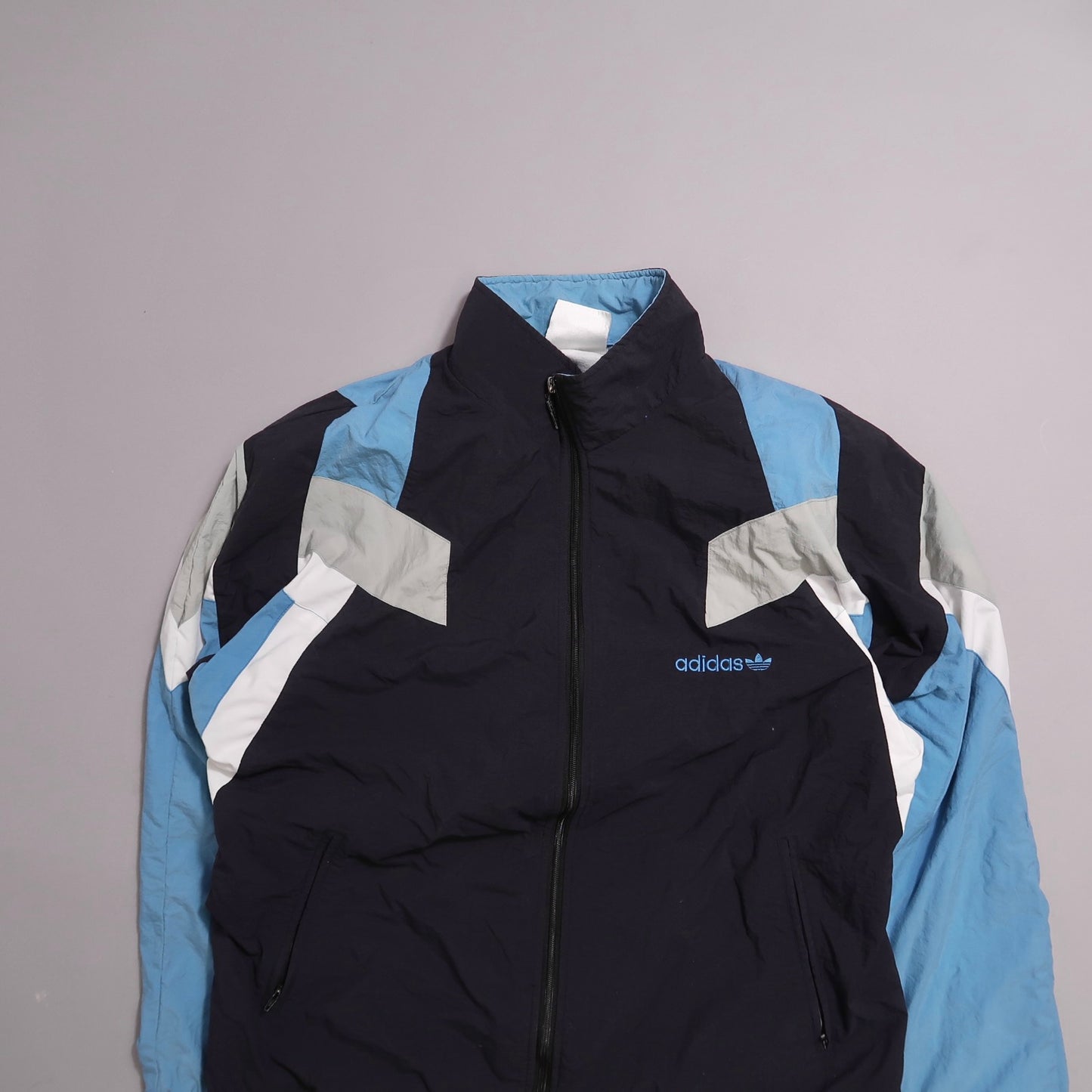Blue and black Adidas track jacket with white and gray accents.