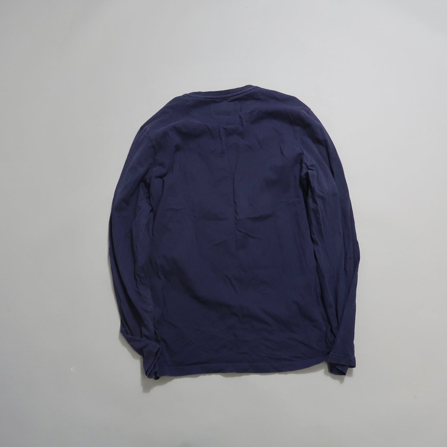 Navy blue long-sleeve shirt laid flat, back view.