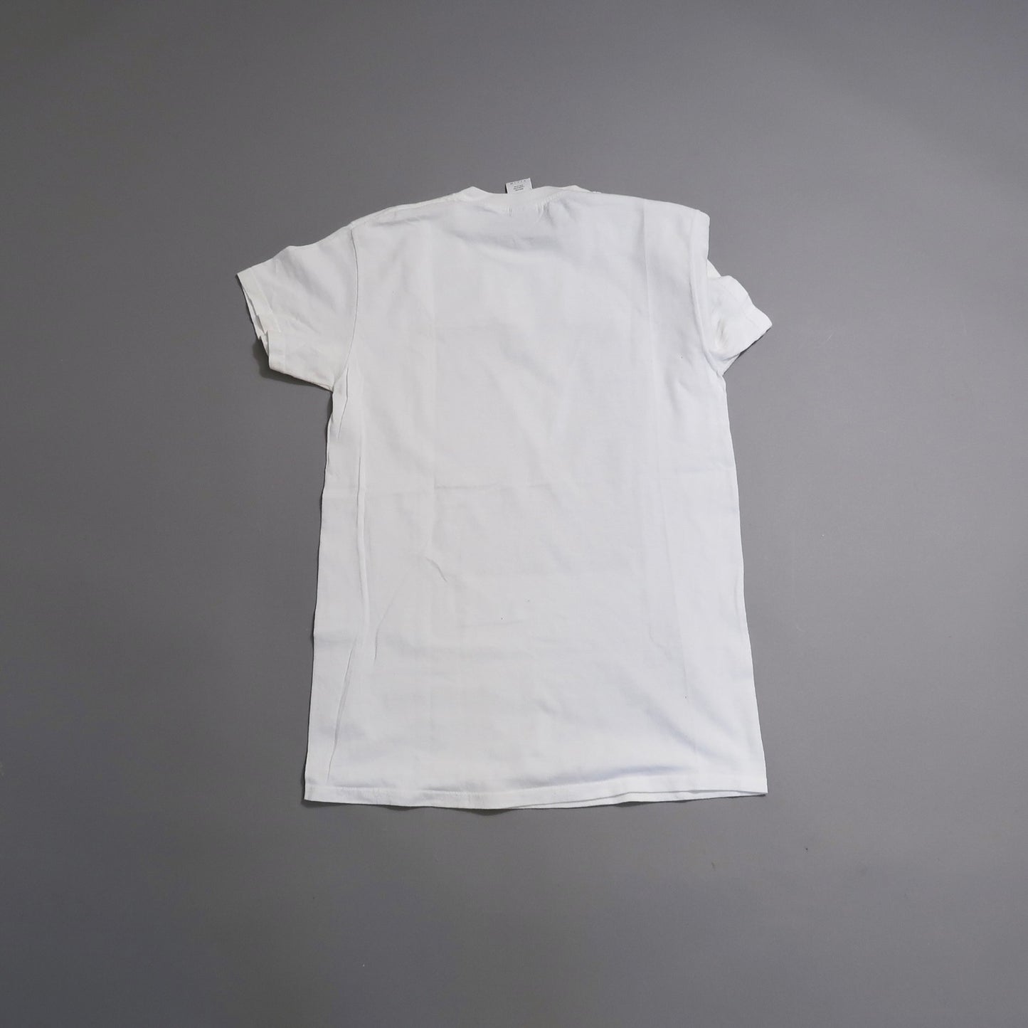 Back view of a plain white T-shirt on a gray background.