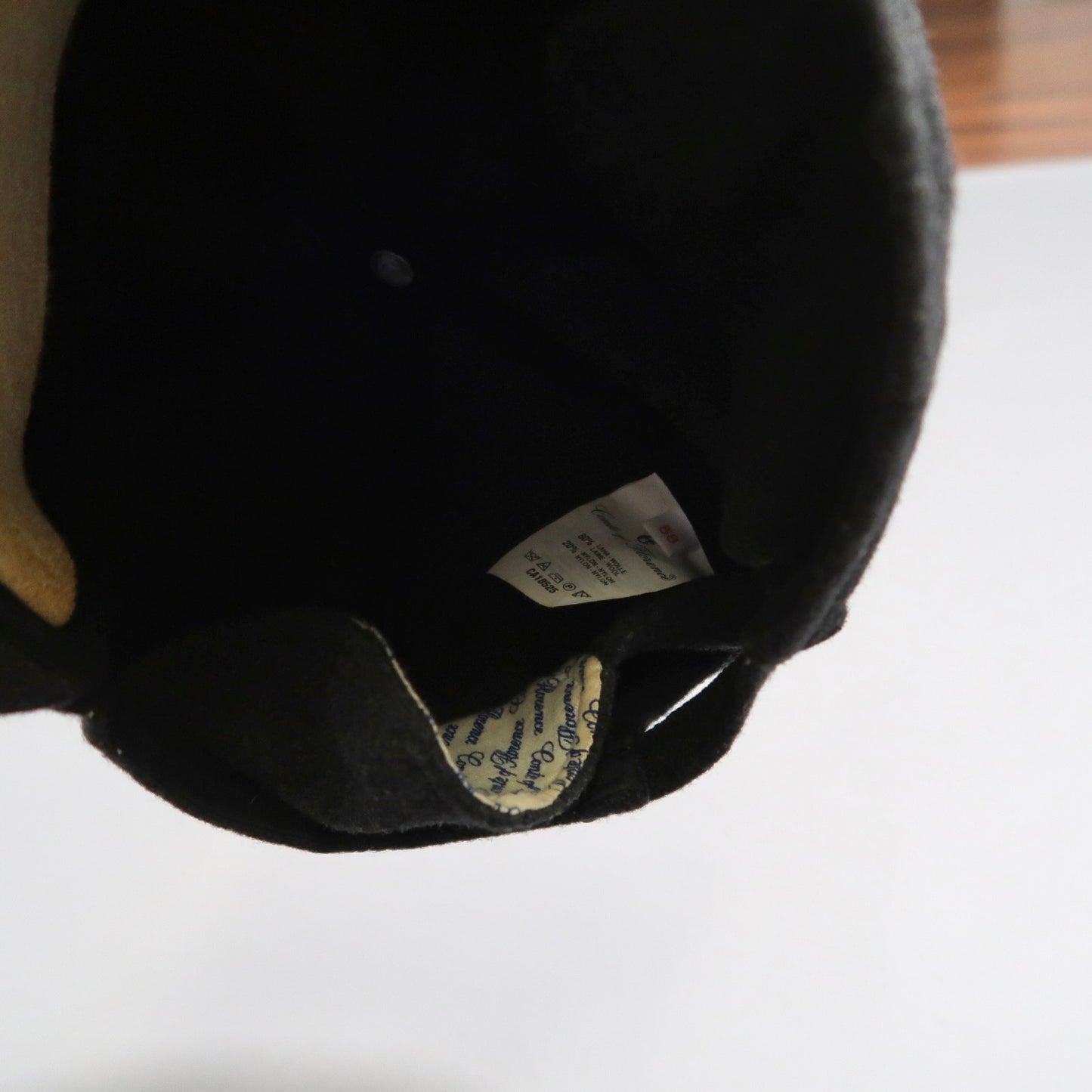 Inside view of a black hat with visible fabric and care labels.