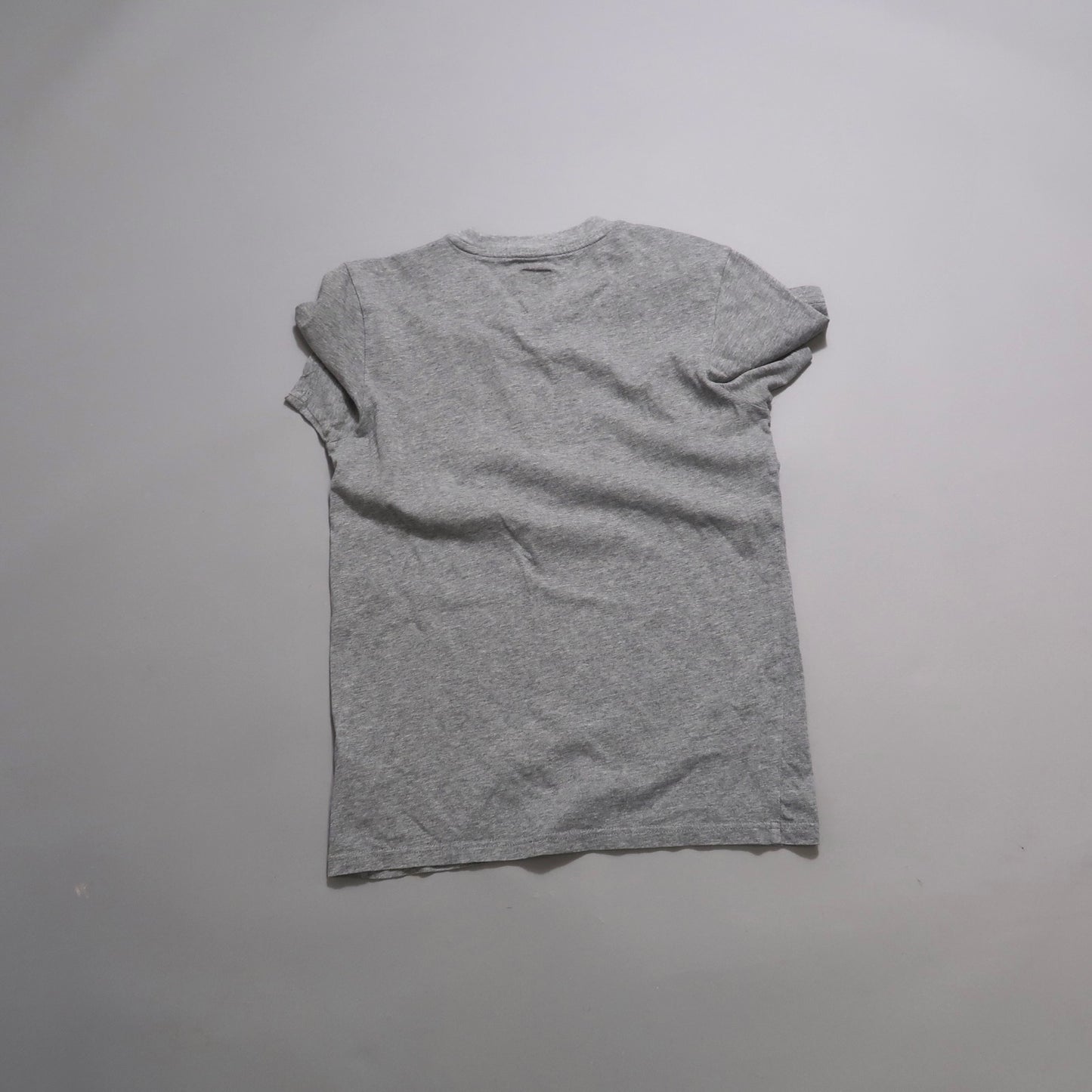 Gray t-shirt lying flat on a light background.