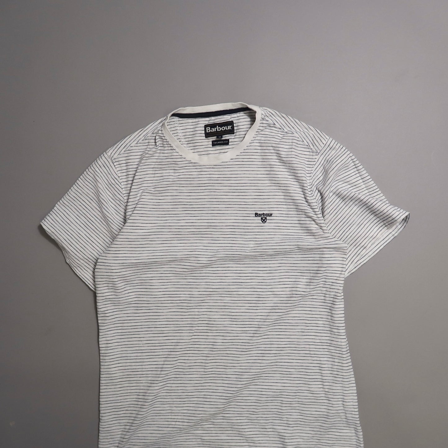 Striped Barbour t-shirt on a gray background.