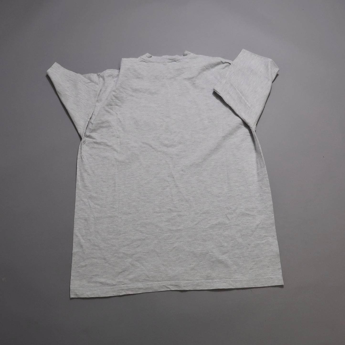Gray double-layered T-shirt laid flat on a neutral surface.