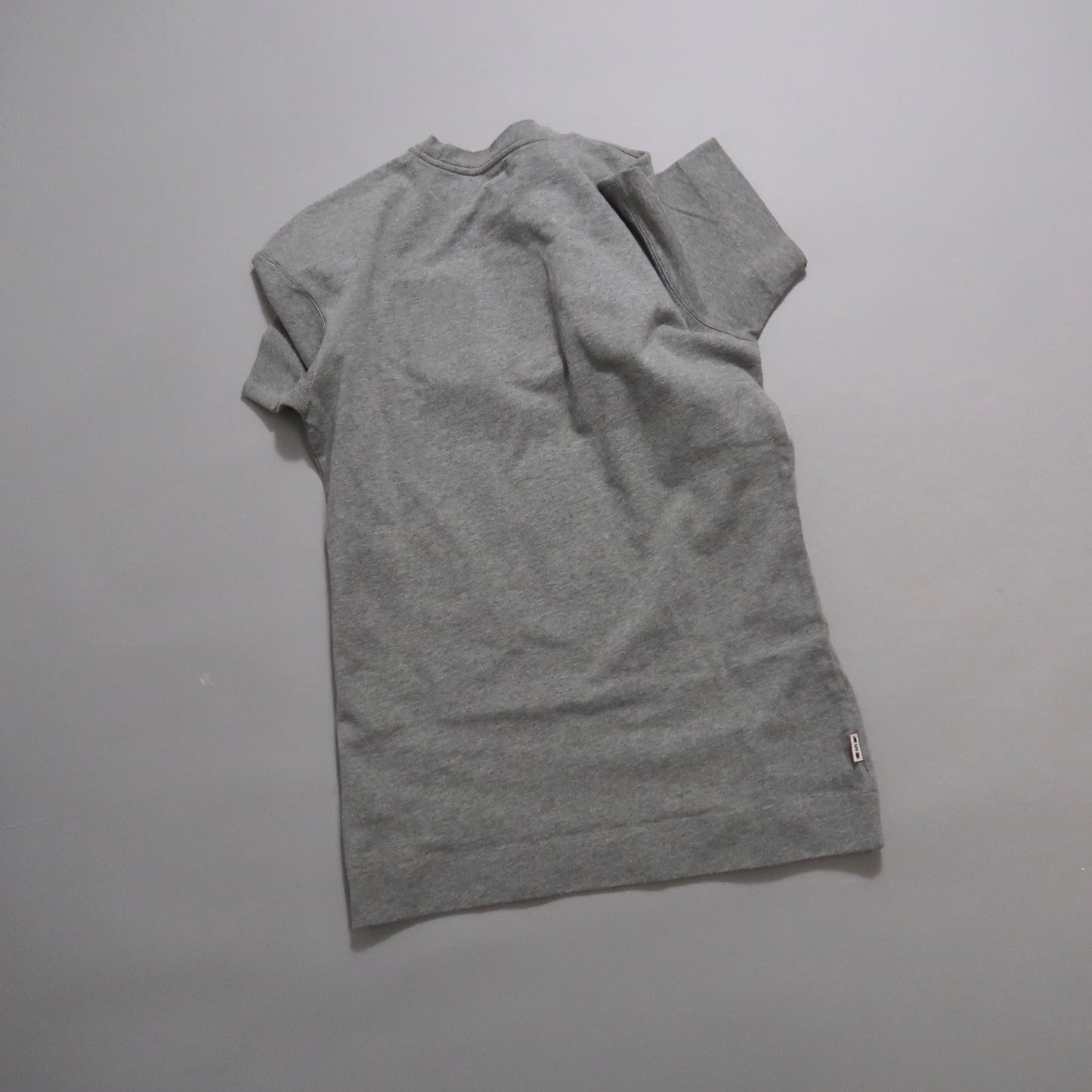 Gray t-shirt lying flat on a plain background.