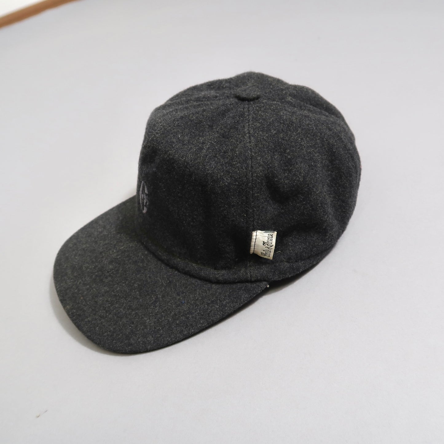Dark gray wool cap with a small tag on the side.