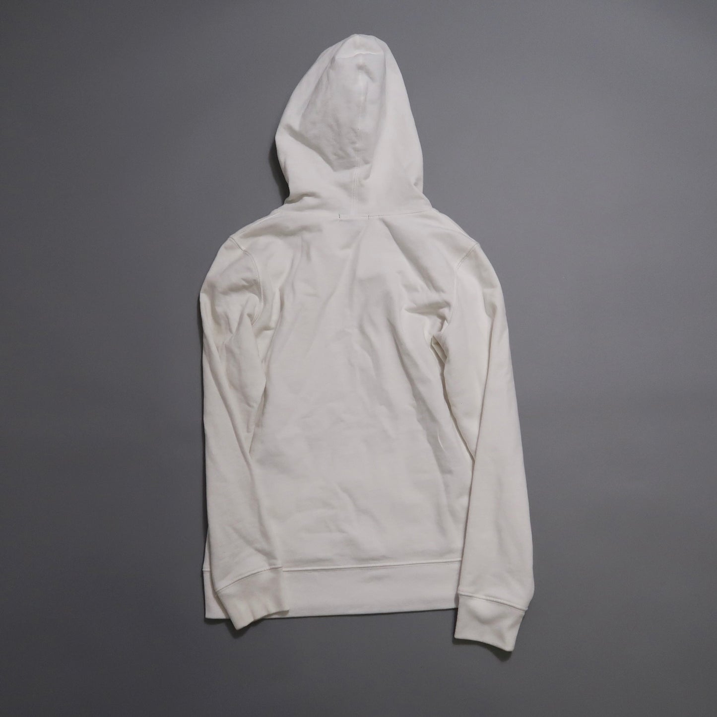 Back view of a plain white hoodie on a gray background.