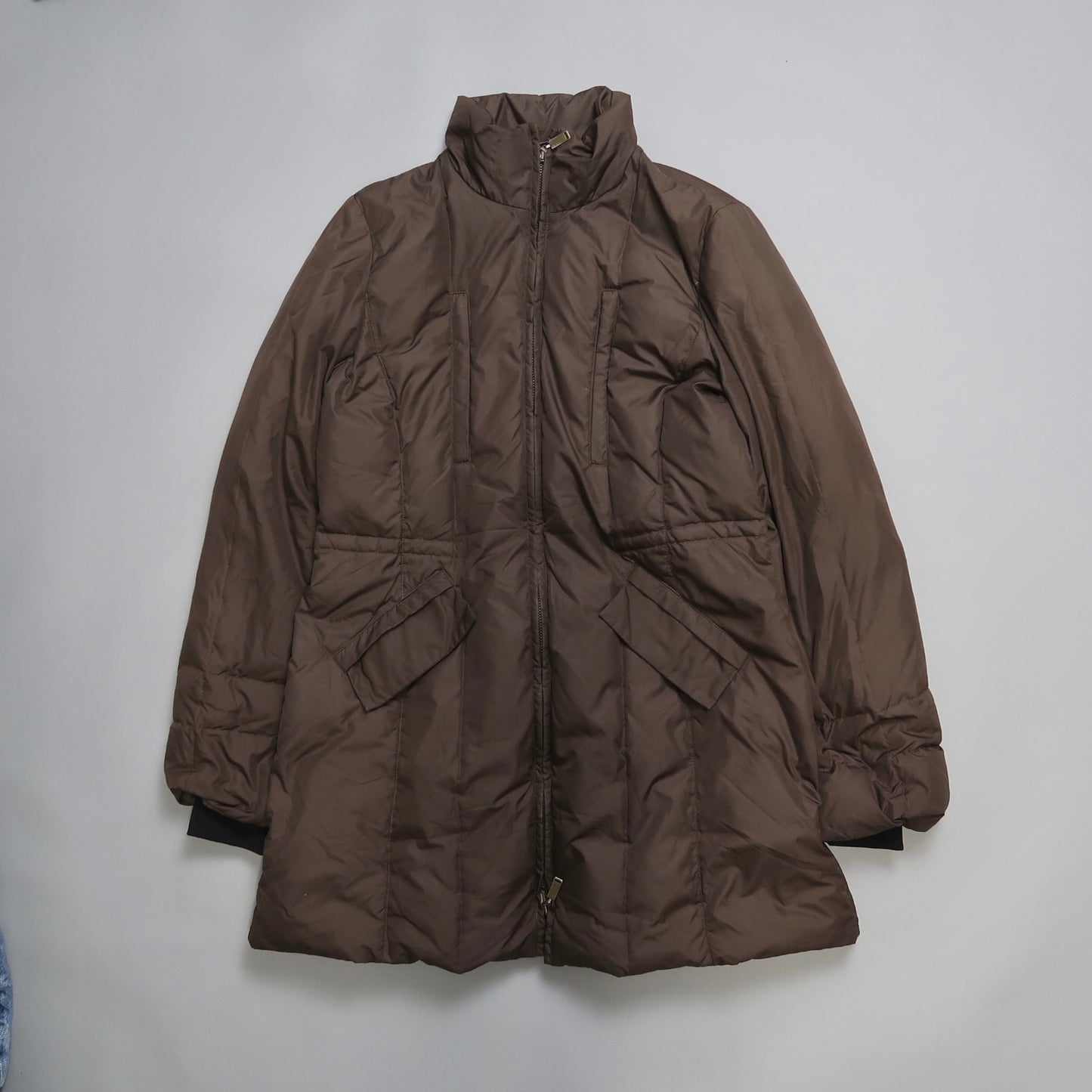 Brown puffed winter coat with zipper, laid flat on a surface.